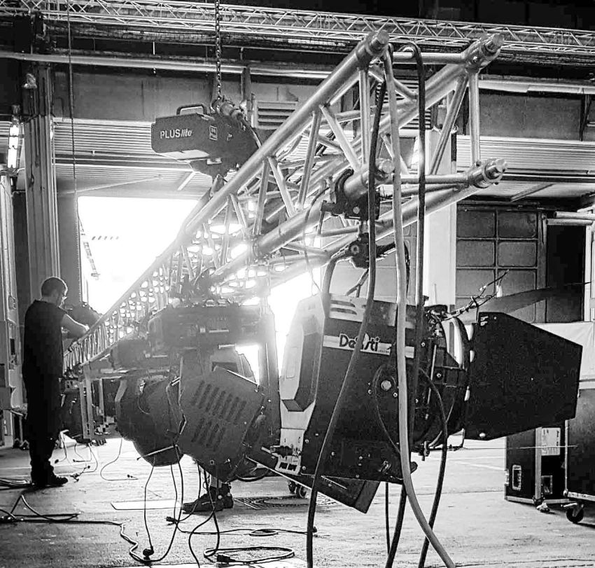 Veranstaltungstechniker bei der Installation von Lichttechnik an eine Traverse